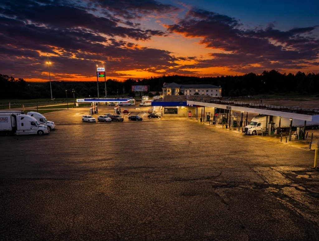 Sunset over Cowboy Truck Stop 2 — Mobil pumps, diesel lanes, and the lot